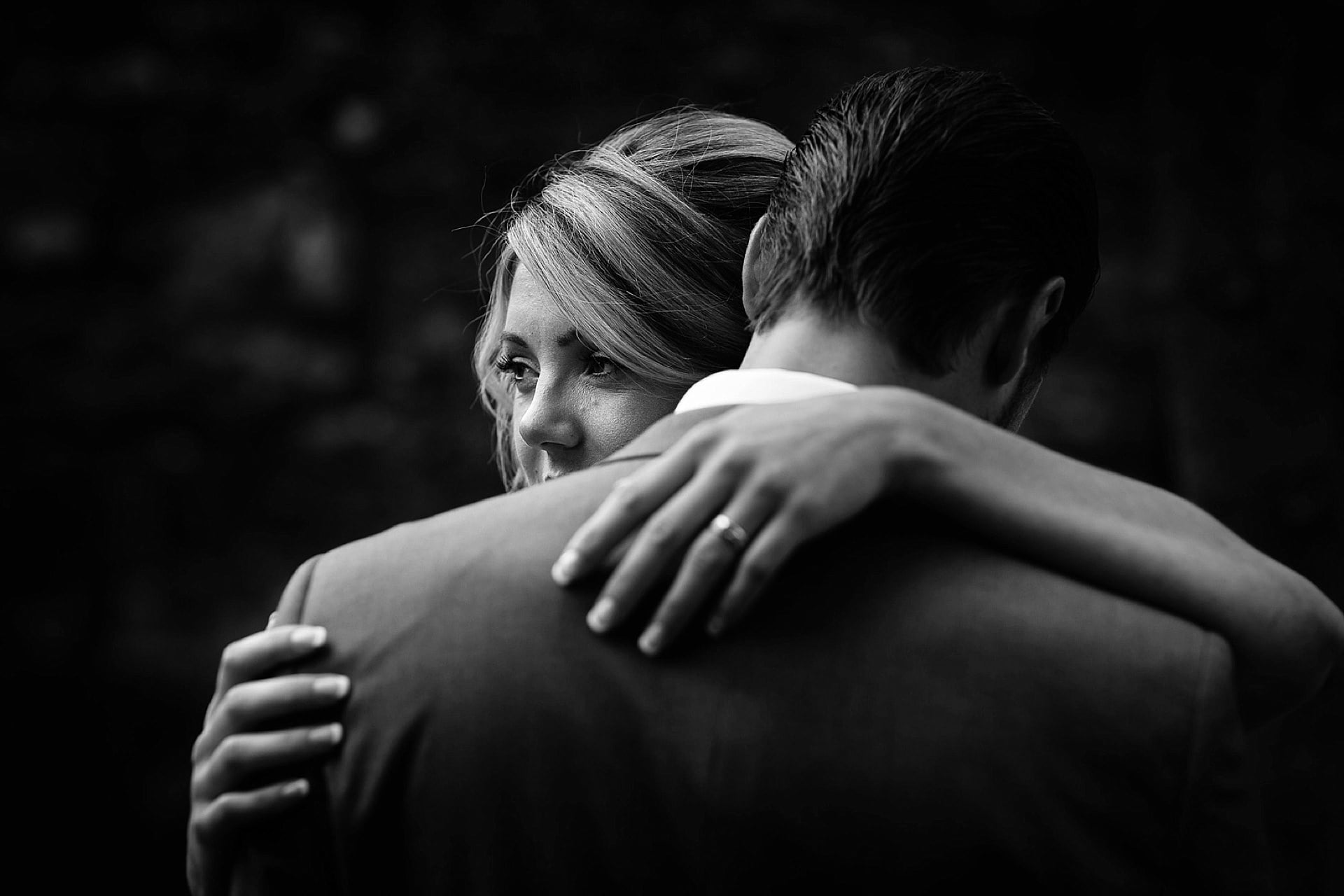 A bride and groom hugging each other in black and white.