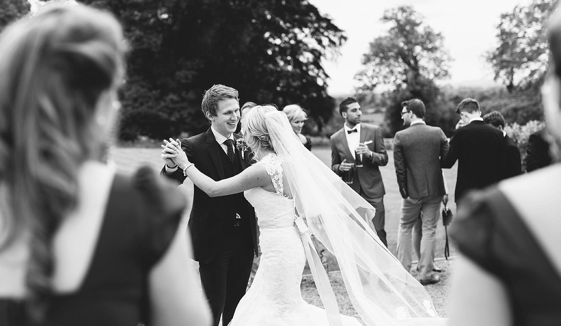 A black and white photo of a bride and groom dancing.