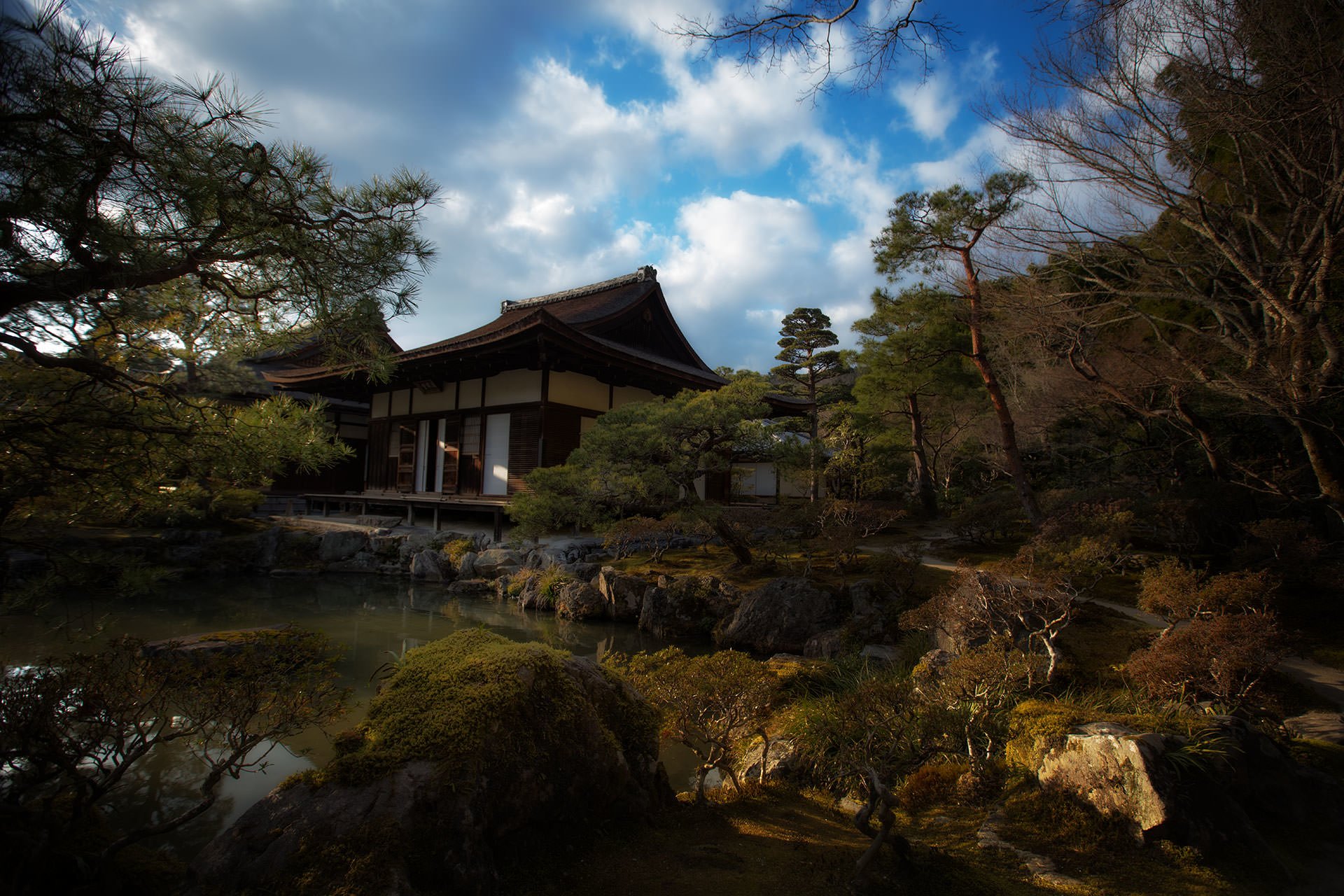 A Japanese landscape surrounded by trees and rocks.