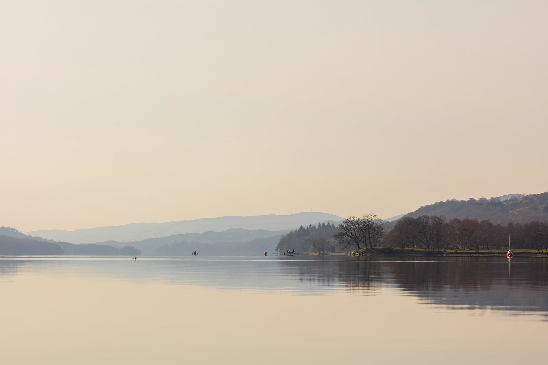 Landscape: A boat on a serene lake surrounded by majestic mountains.