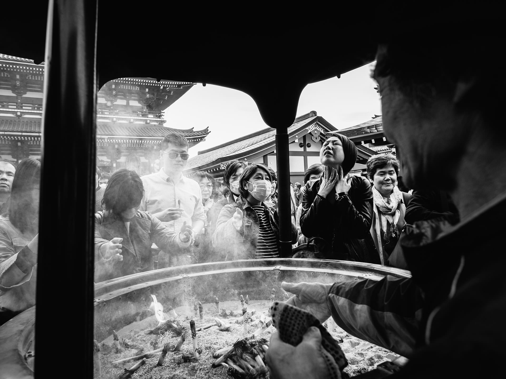 A black and white photo of a group of people at a temple in Japan.