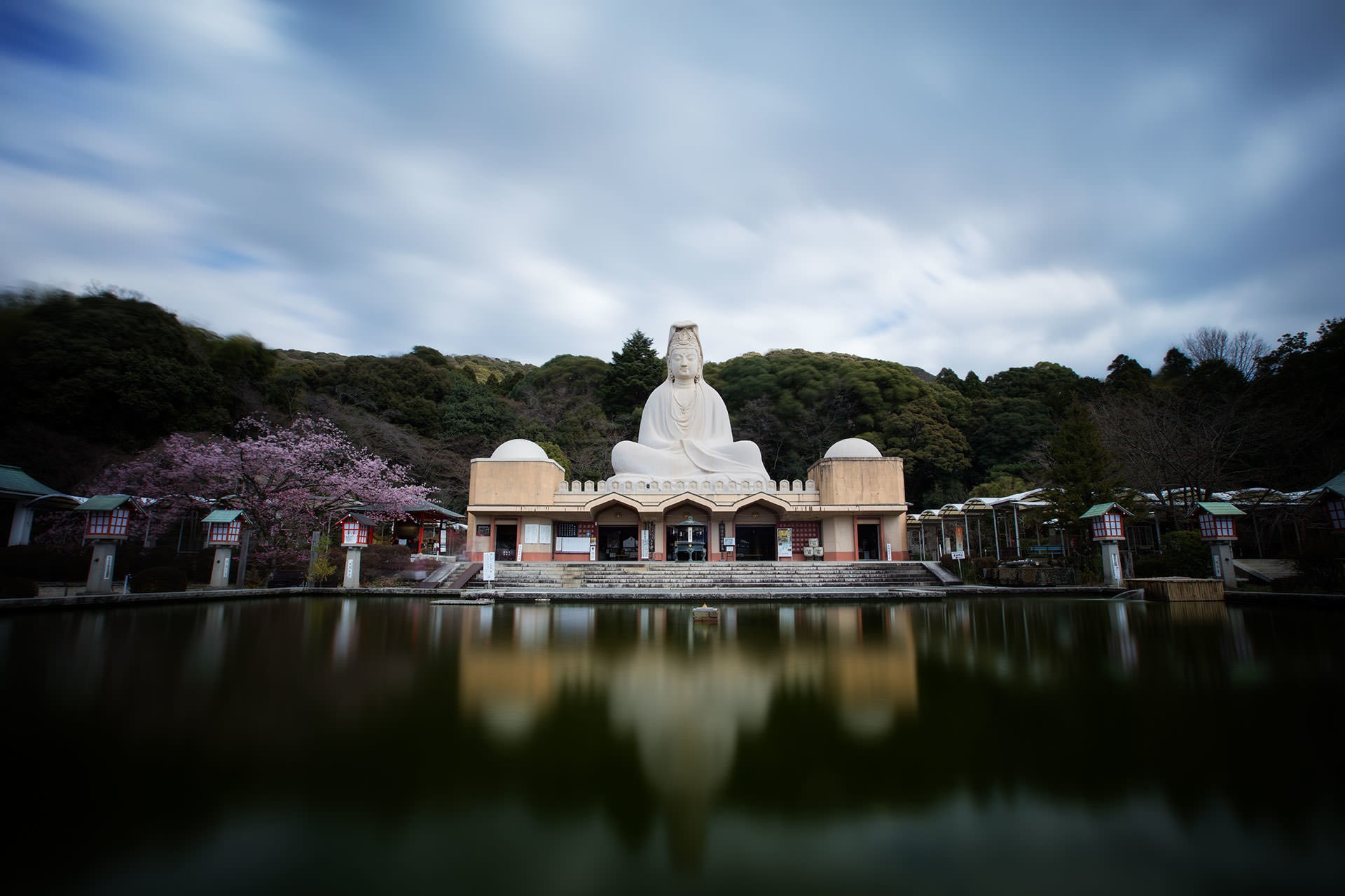 Description: A tranquil pond landscape featuring a serene white Buddha statue.