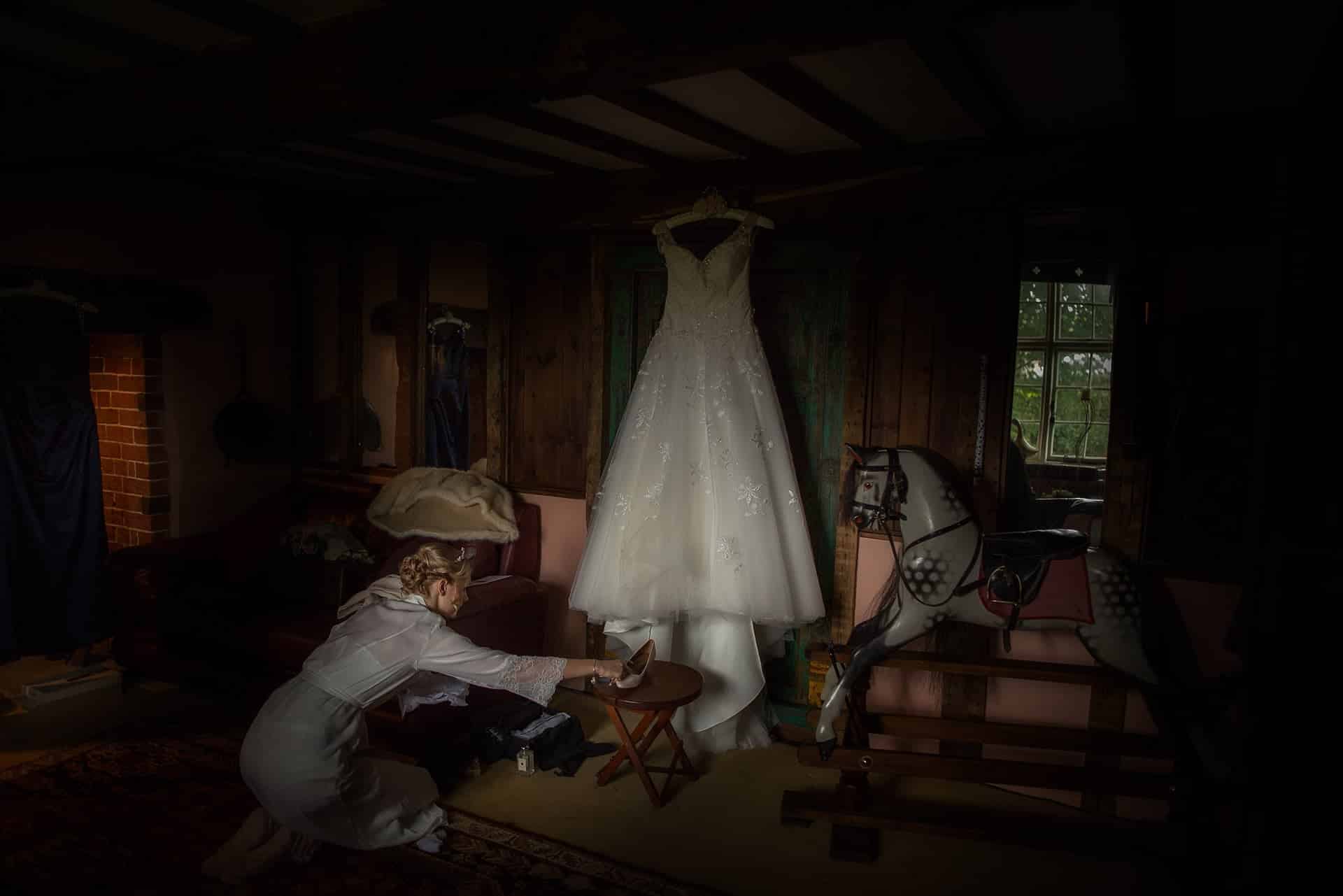 Sarah places her shoes by her dress, while Shropshire Documentary wedding photographer pbartworks captures the scene