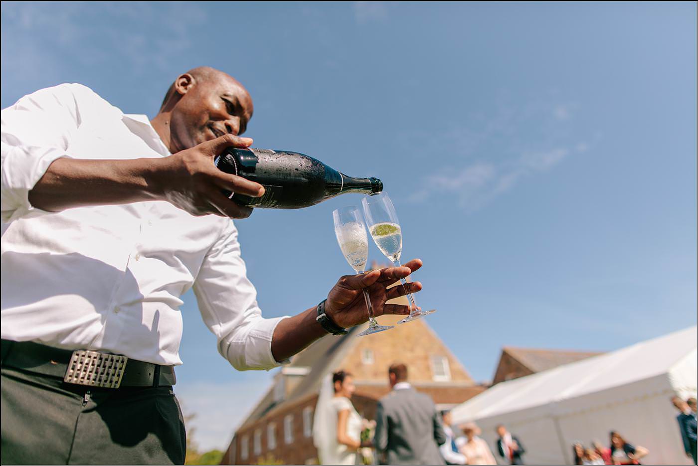 bride and groom being served a drink with Shropshire destination photographer