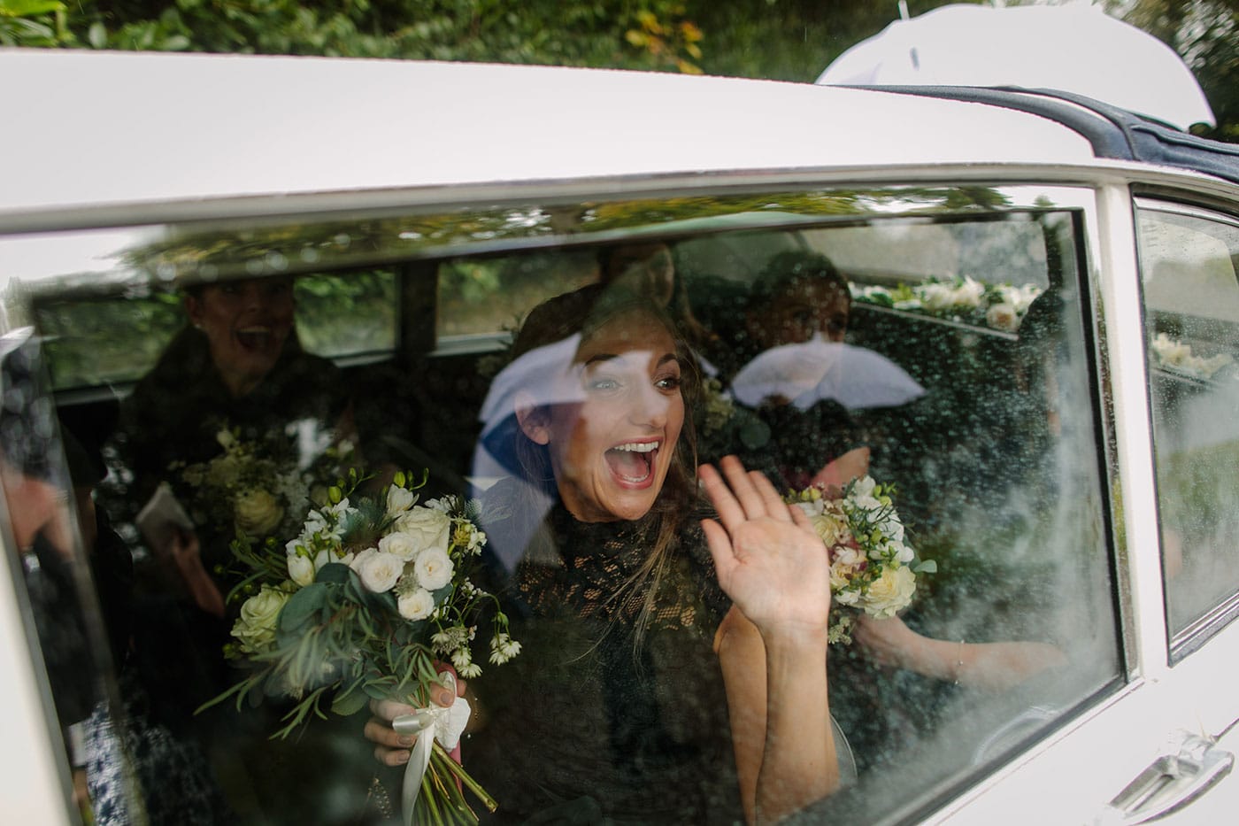 Emma's bride waving out of the window of a car leaving Tyn Dwr Hall.