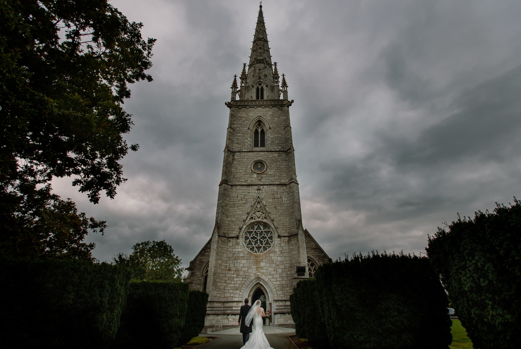A bride and groom standing in front of a church.