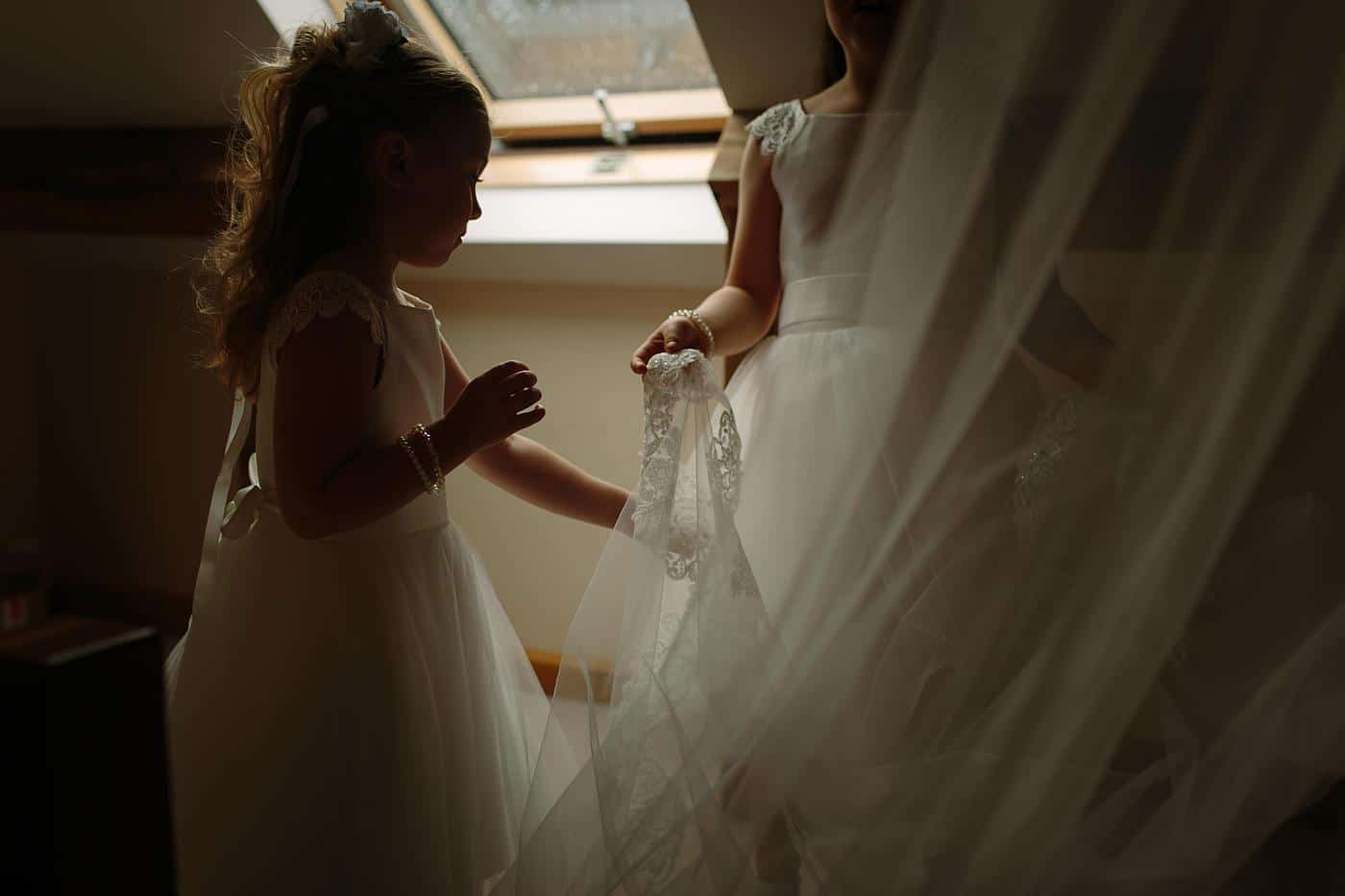 flower girls playing with a brides veil