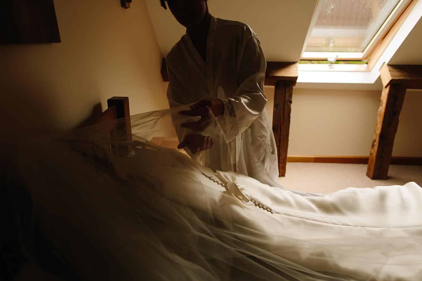 a wedding dress being arranged by the bride