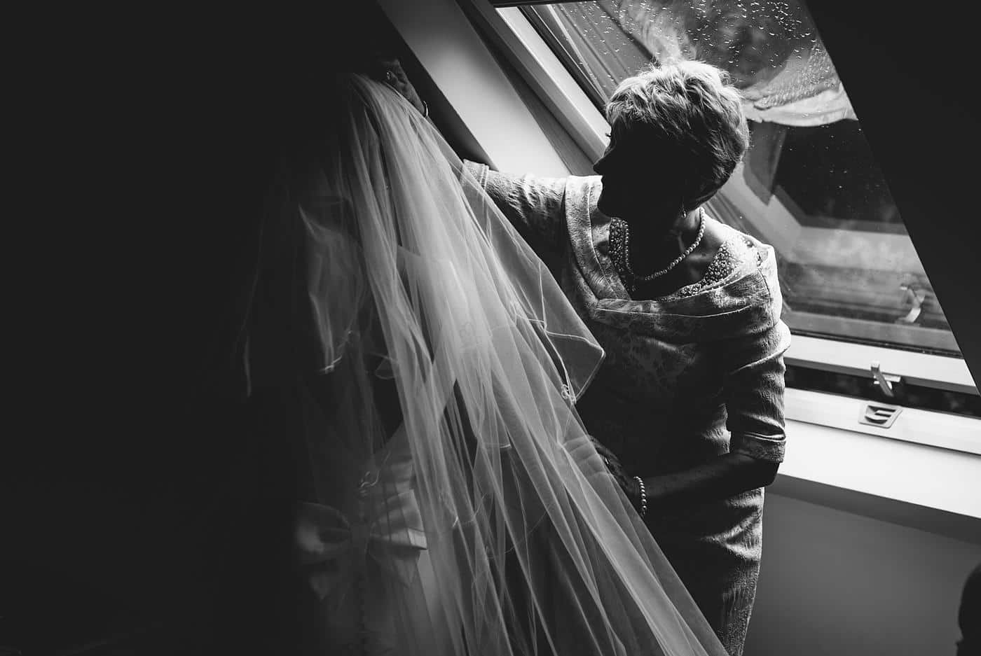 the brides mother checking her daughters veil