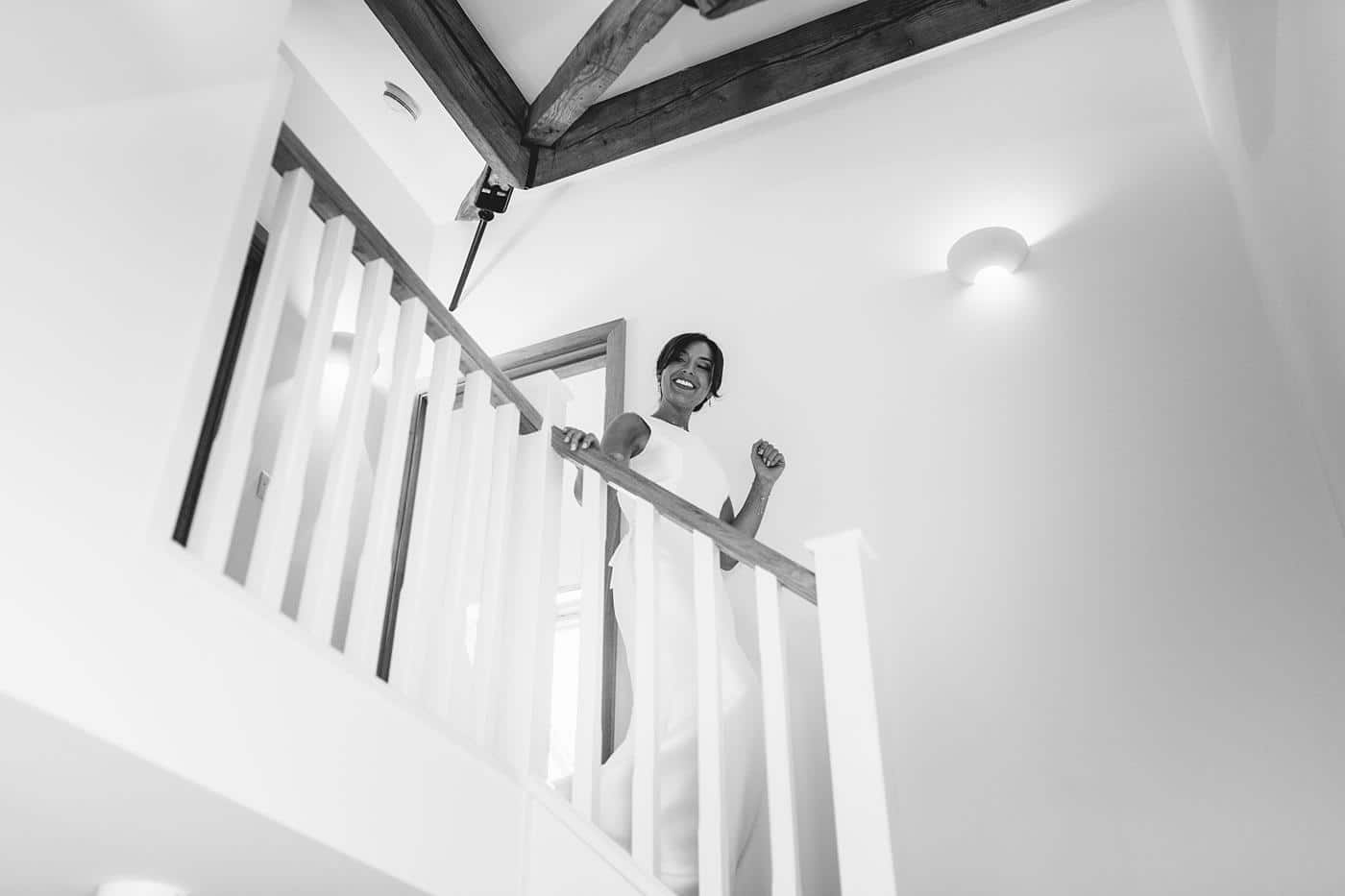 Black and white photo of a woman standing on a staircase in Wistanstow Village Hall Wedding.