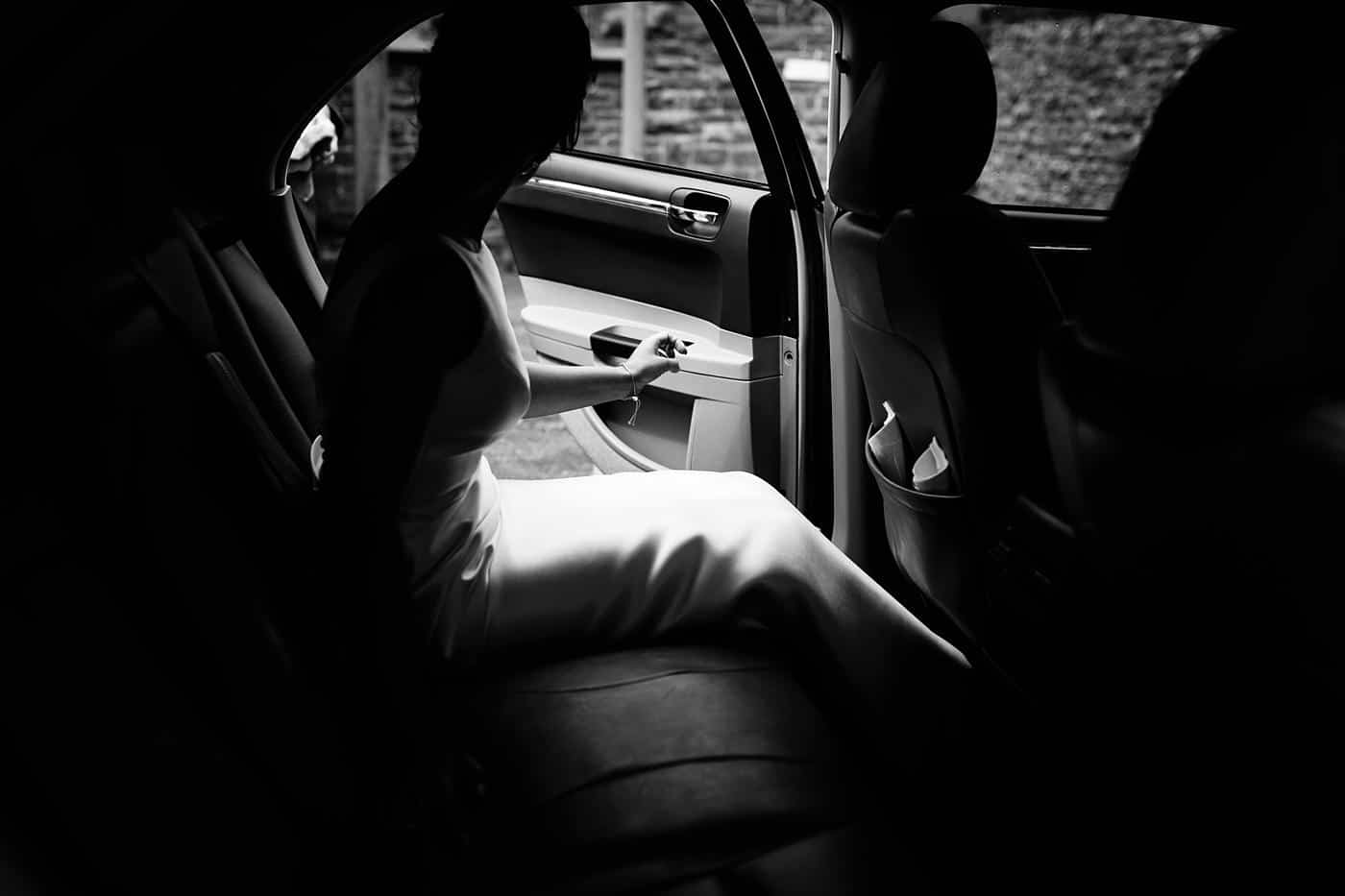 A bride sitting in the back seat of a car on her way to her Wistanstow Village Hall Wedding.