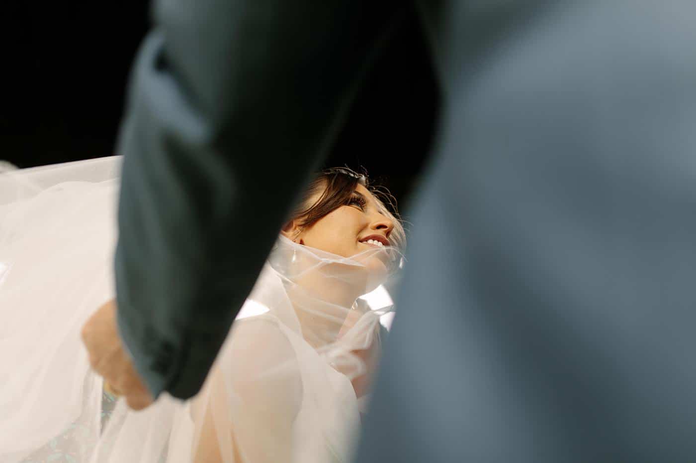 A bride is holding her veil as she walks down the aisle at her Wistanstow Village Hall wedding.