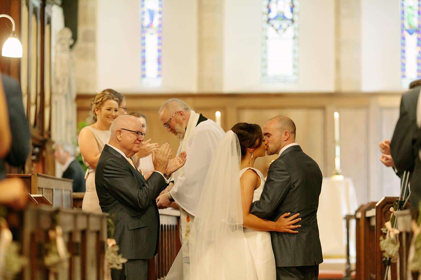 A bride and groom sharing a kiss in Wistanstow Village Hall on their wedding day.