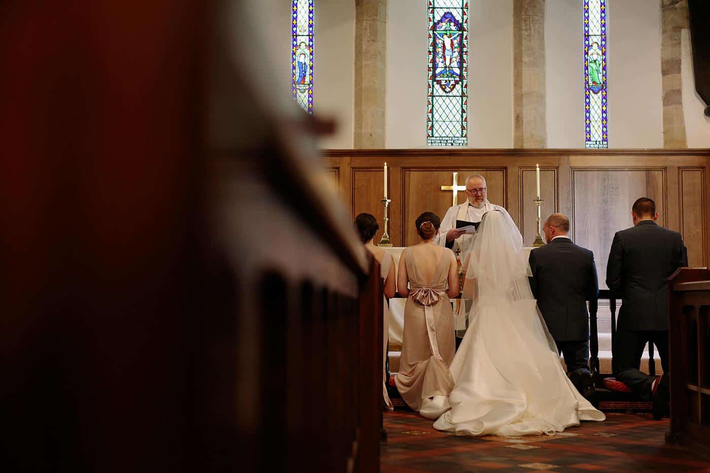 A bride and groom walking down the aisle at Wistanstow Village Hall on their wedding day.
