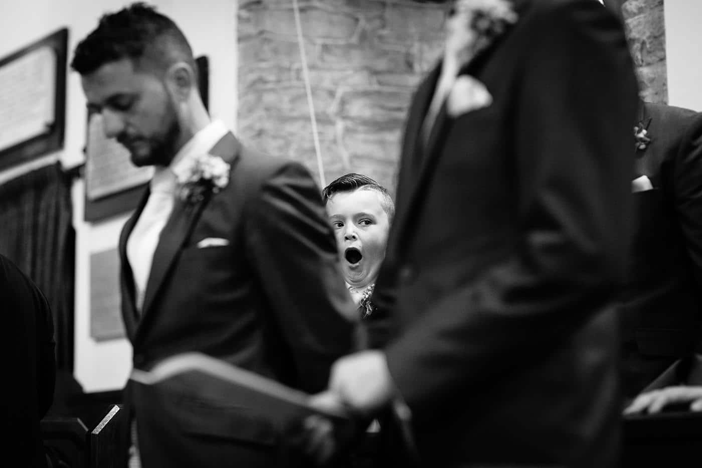 At the beautiful Wistanstow Village Hall Wedding, two distinguished gentlemen in suits engage in a mutual gaze.