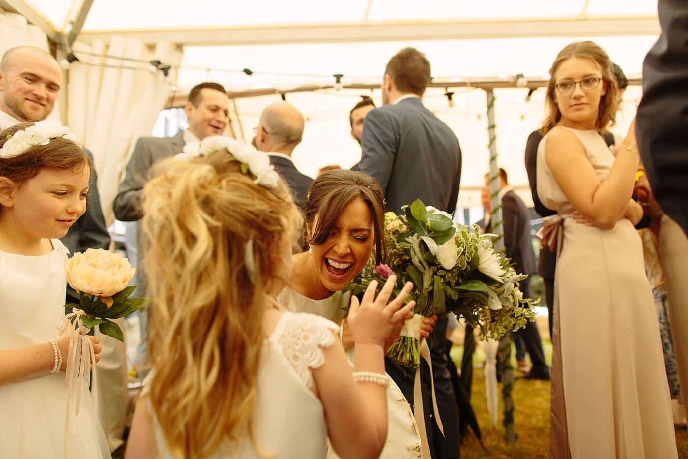 A girl in a white dress is holding a bouquet of flowers at a Wistanstow Village Hall Wedding.
