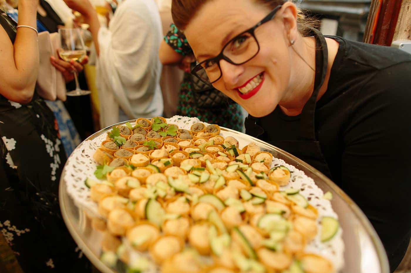 A woman holding a tray of food at a Wistanstow Village Hall wedding.