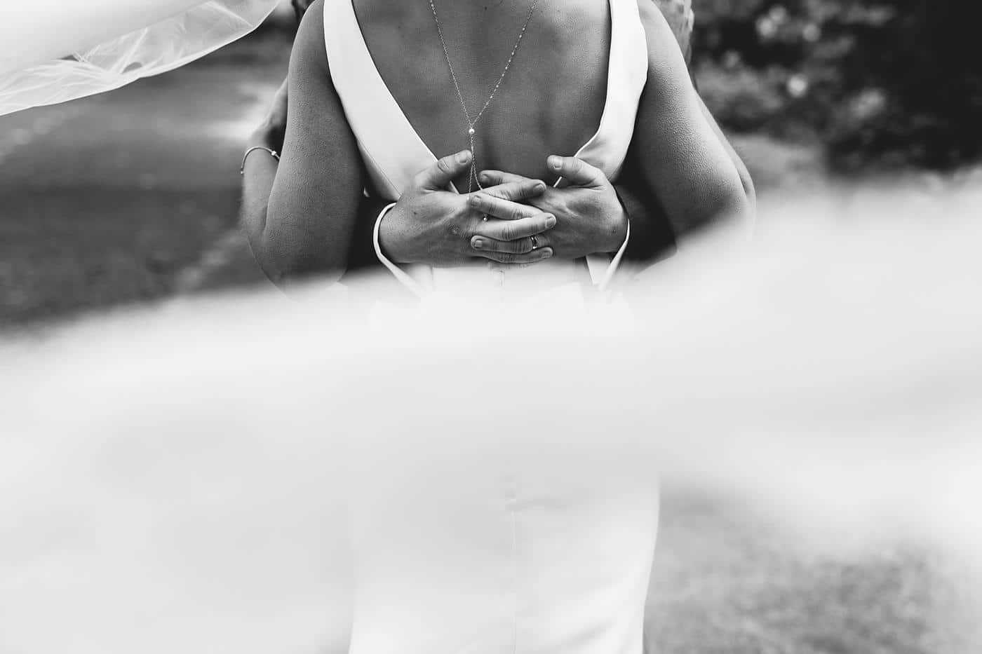 A black and white photo of a bride and groom hugging at their Wistanstow Village Hall wedding.