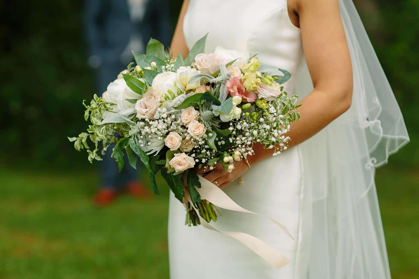 A bride holding a bouquet in the Wistanstow Village Hall Wedding field.