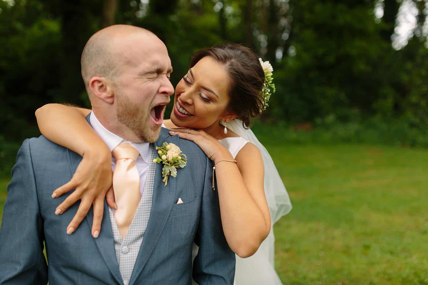 A bride and groom hugging in Wistanstow Village Hall.