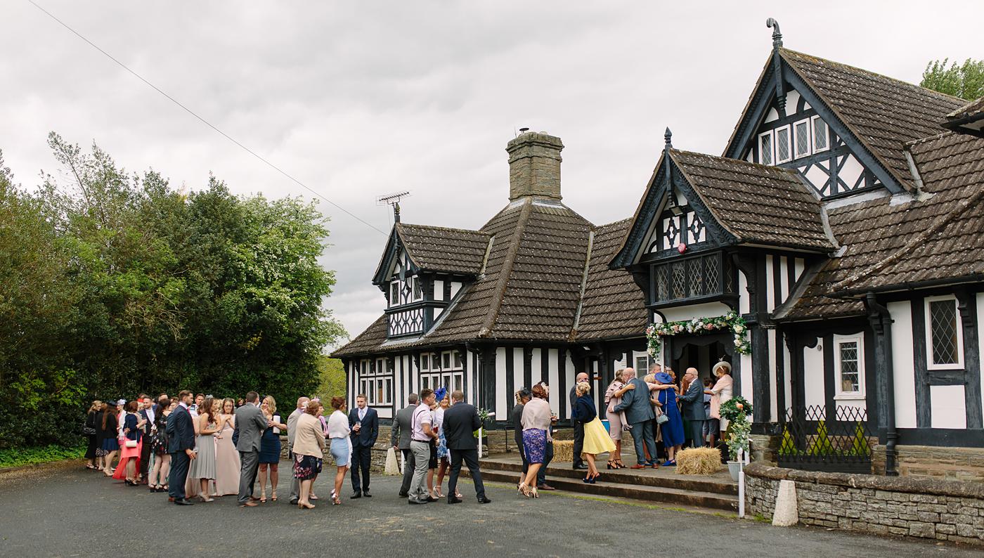 Wedding attendants gathered outside of Wistanstow Village Hall.