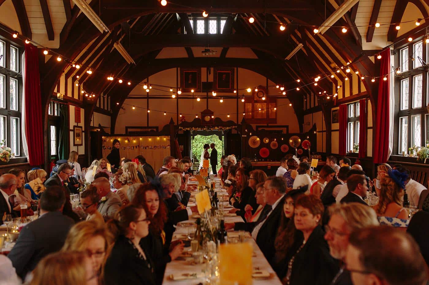 Wistanstow Village Hall Wedding - A group of people sitting at a table in a large room.
