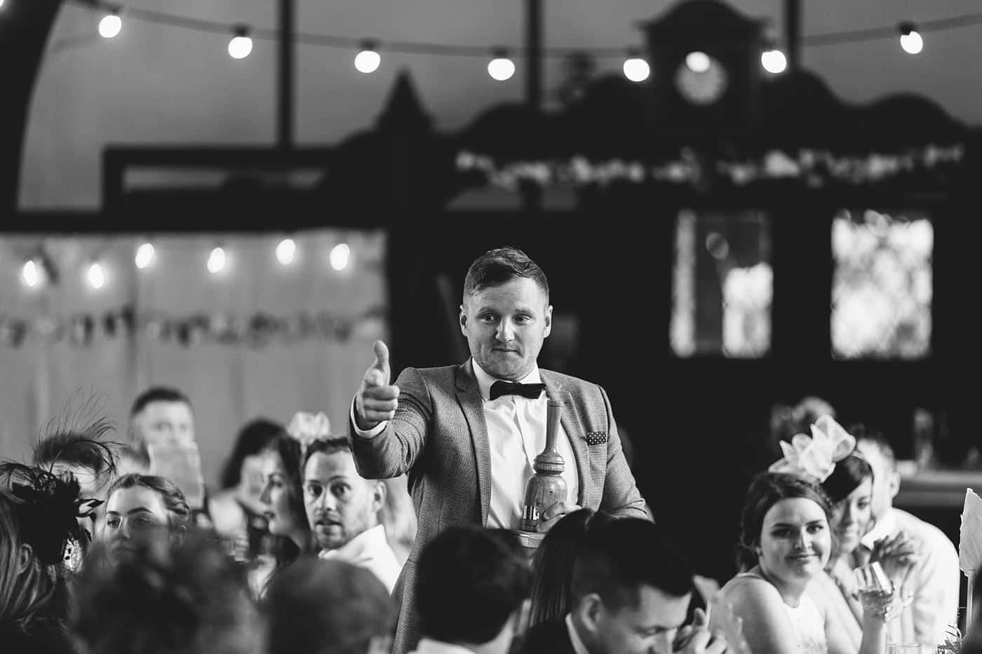A black and white photo of a man giving a thumbs up at Wistanstow Village Hall Wedding.