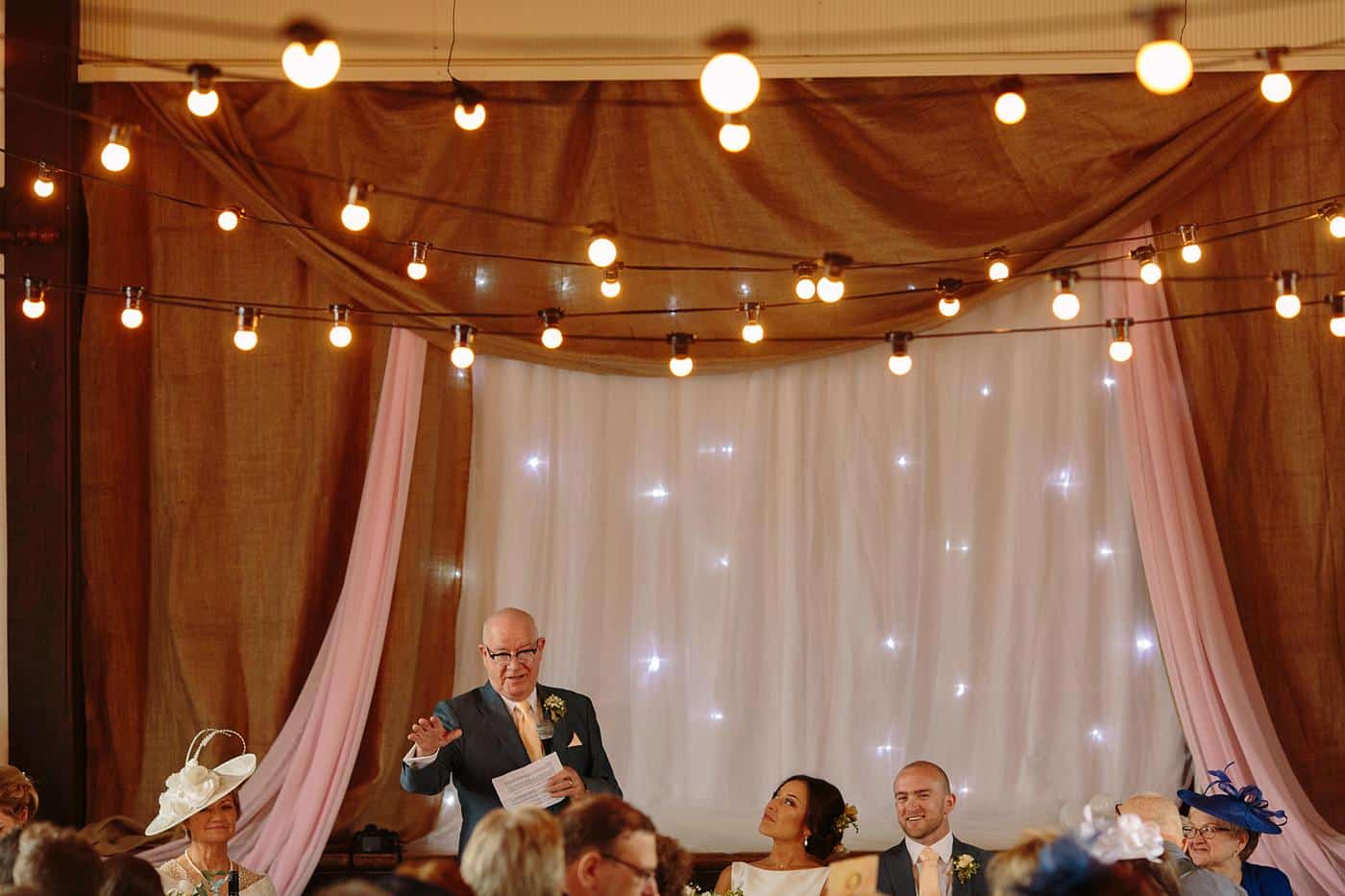A man is giving a speech at a Wistanstow Village Hall wedding.