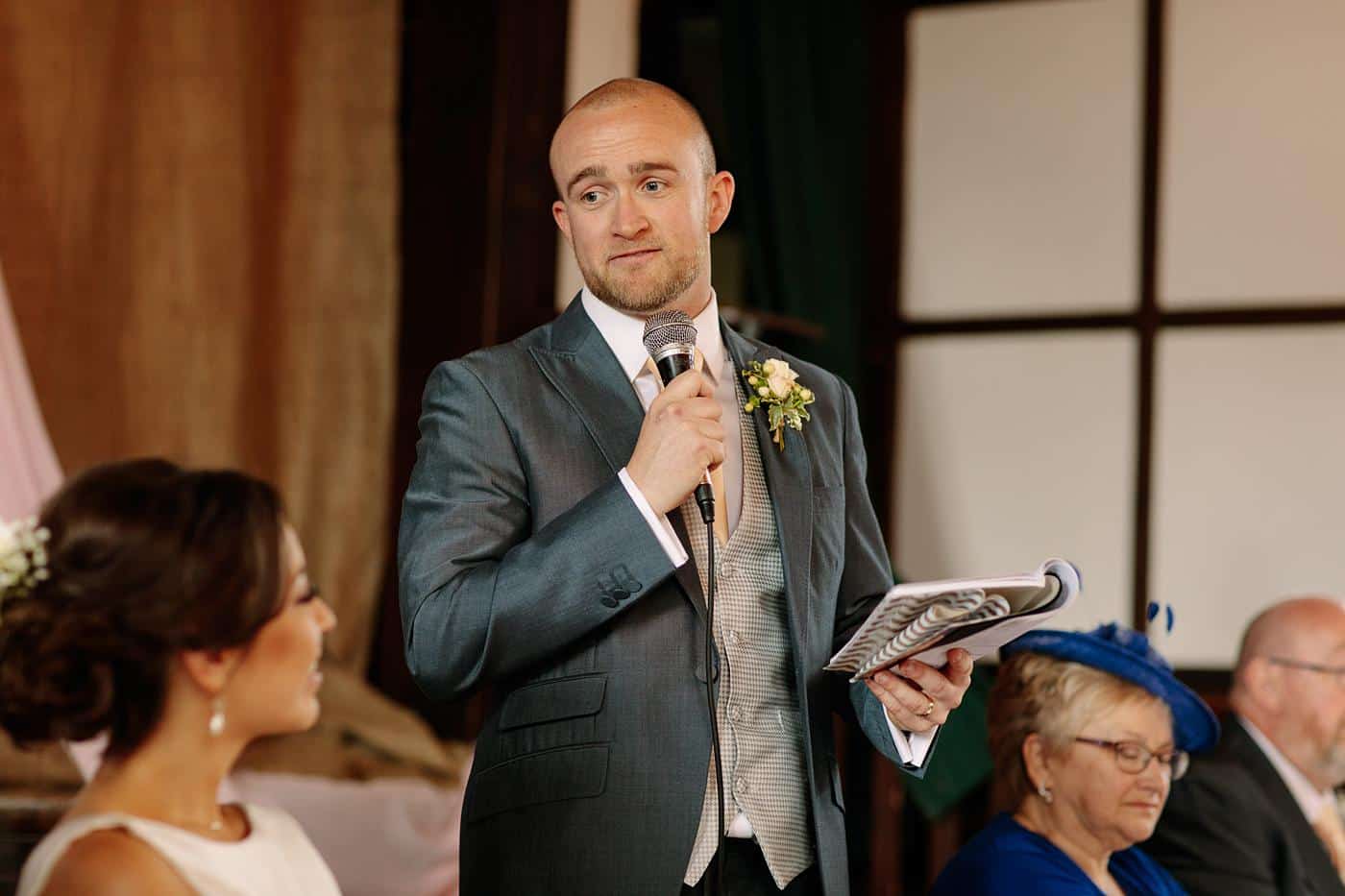 A man is giving a speech at a Wistanstow Village Hall wedding.