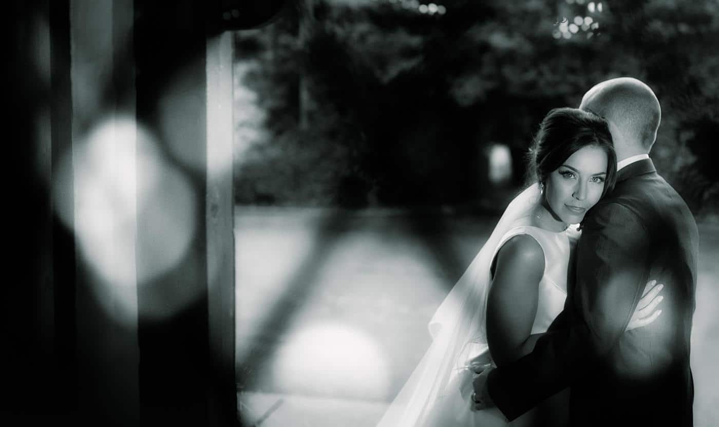 A black and white photo of a bride and groom hugging at their Wistanstow Village Hall wedding.