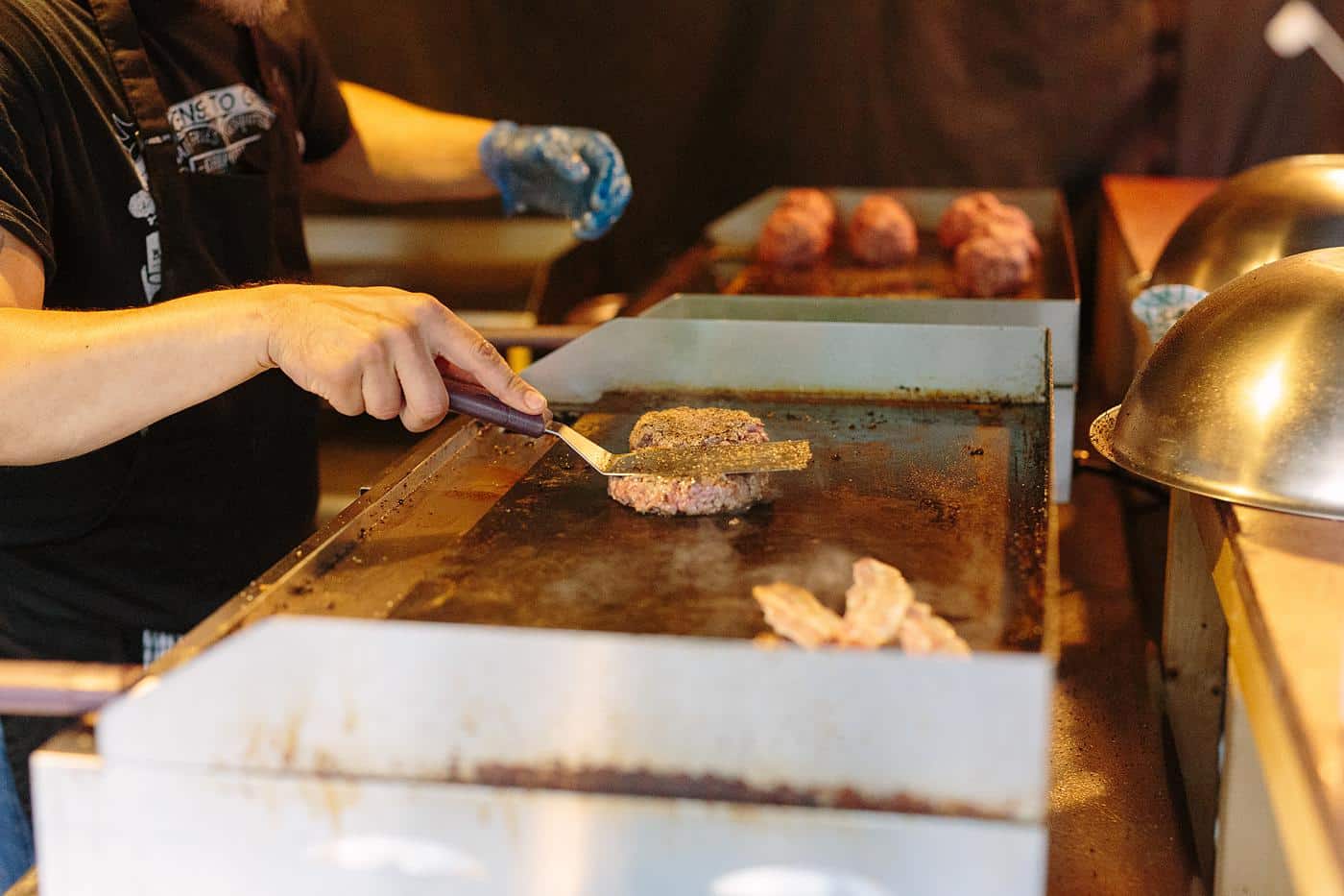A man is grilling meat at a Wistanstow Village Hall wedding.