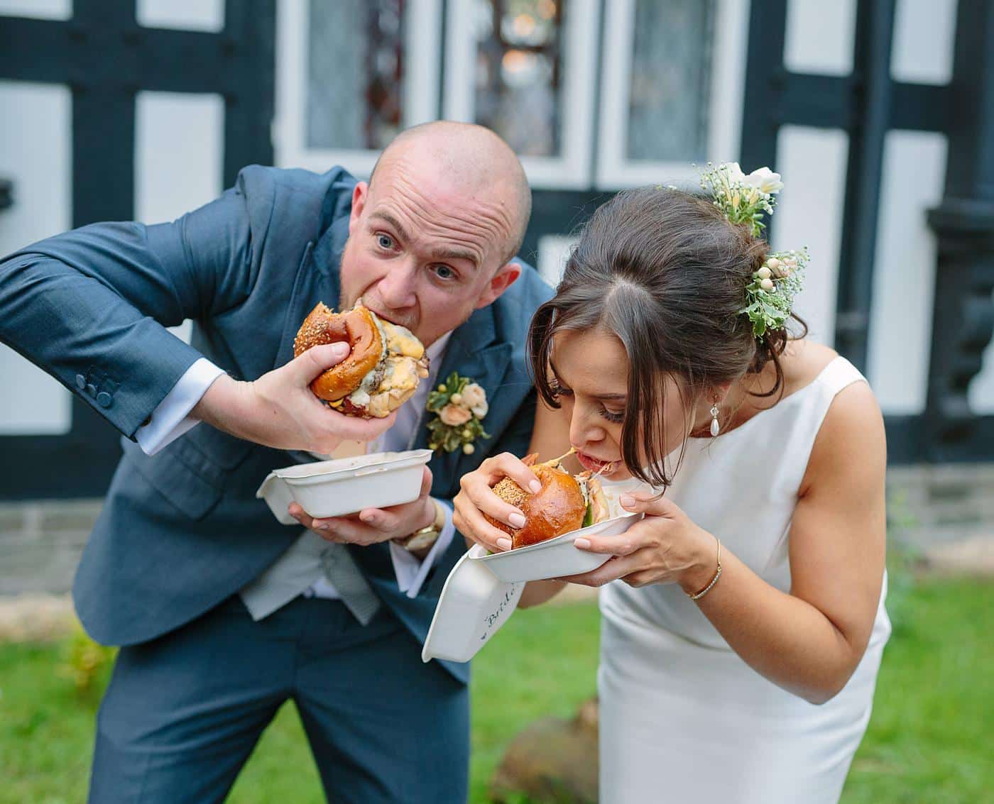 A couple enjoying a hot dog at their Wistanstow Village Hall wedding.