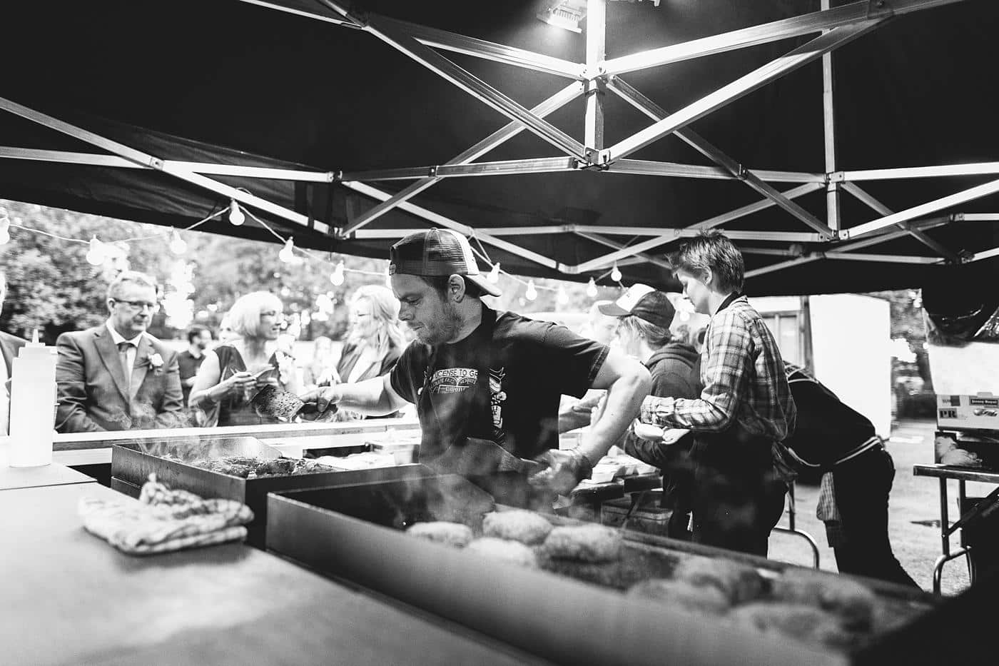 A group of people preparing food under a tent at Wistanstow Village Hall Wedding.
