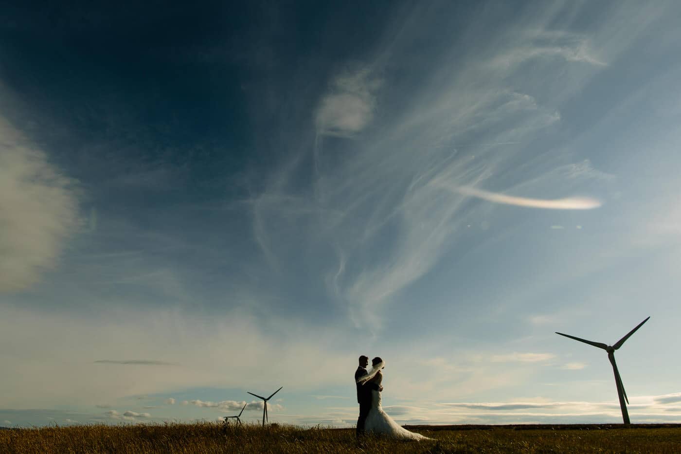 Bride and Groom set against wind turbines at a North Wales Wedding