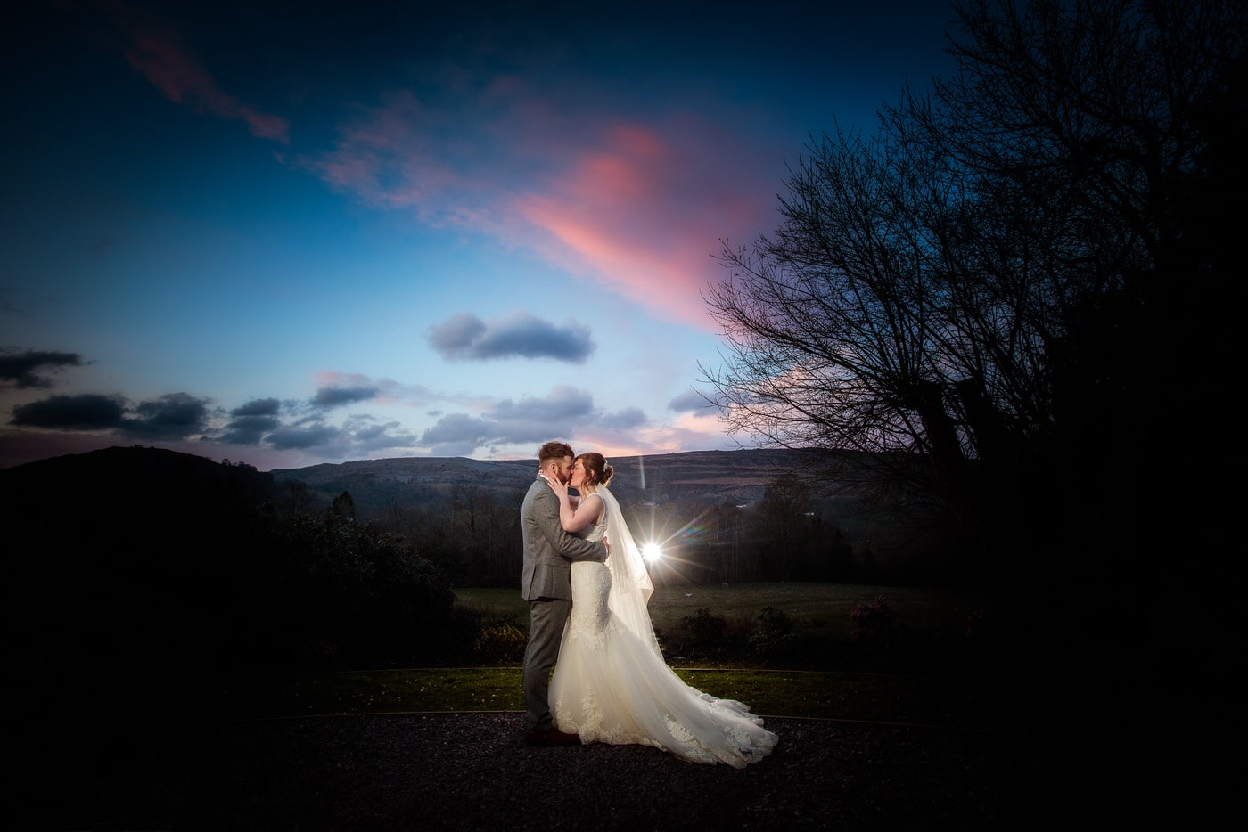 at a Tyn Dwr Hall Wedding the bride and groom take time out to enjoy the sunset and share a kiss