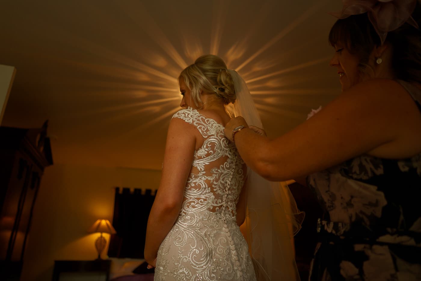 this final touches as the bride is placed into her dress