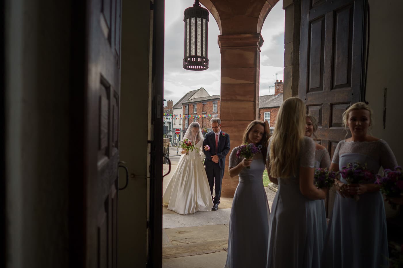 bride and her father say prayers prior to entering the church for the wedding