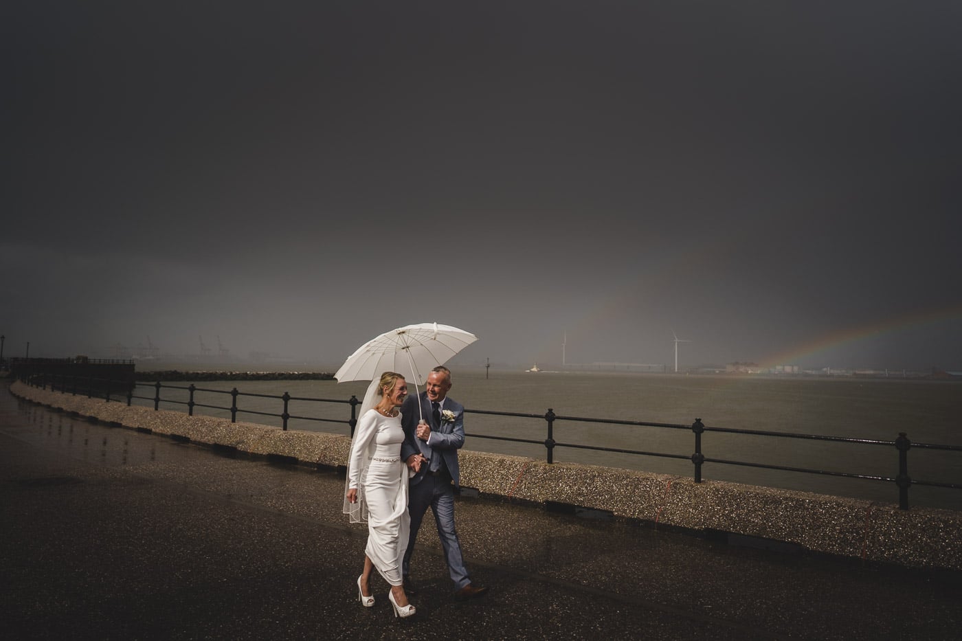 bride and groom take a walk alongside the river mersey in Liverpool