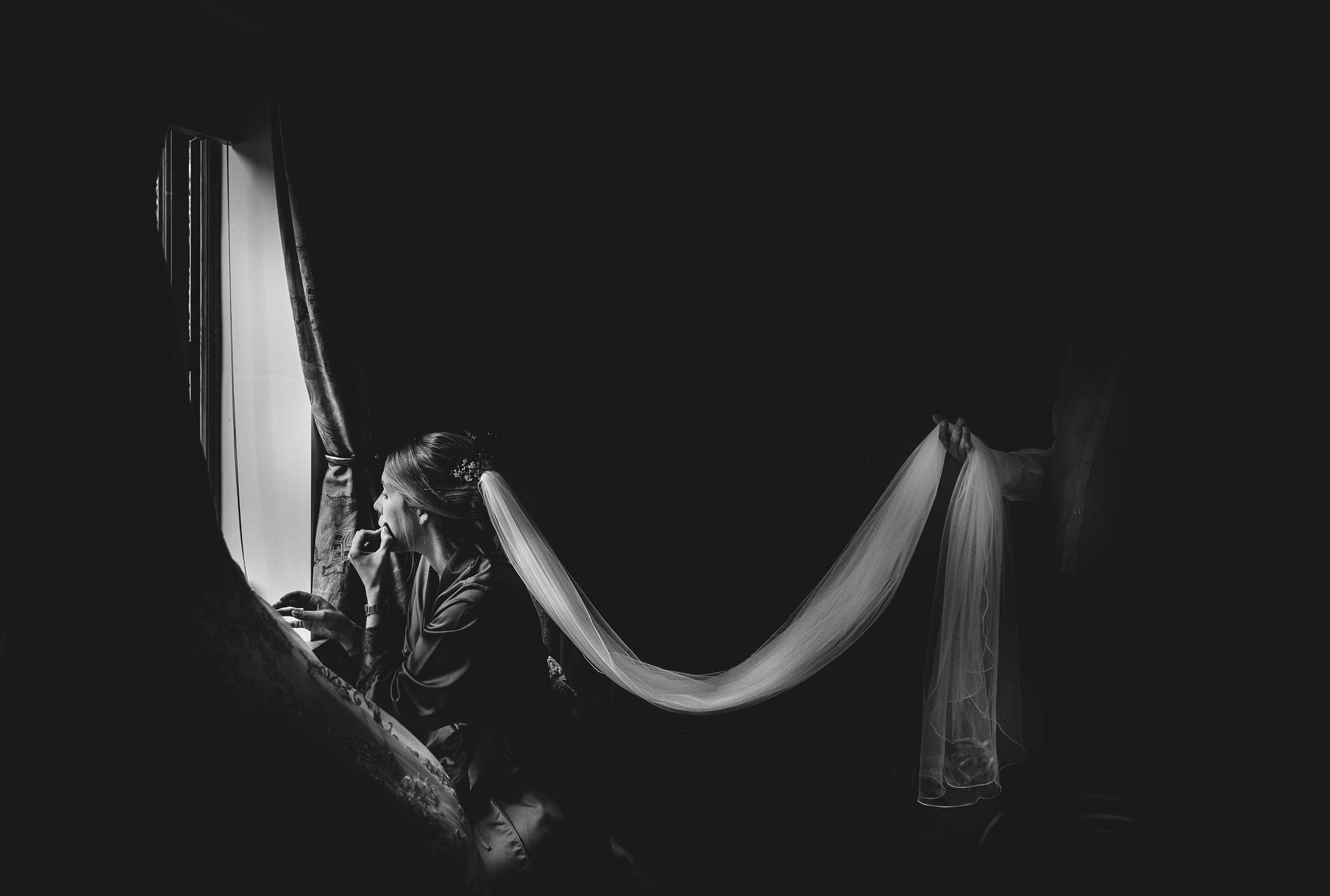 the bride is given a helping hand as she gets ready for her wedding at rowton castle