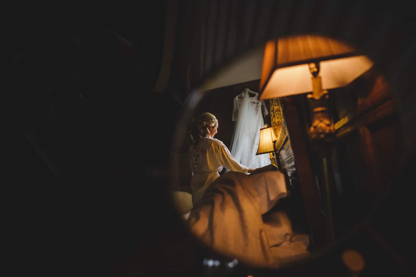 bride tends dress at Soulton Hall in Shropshire