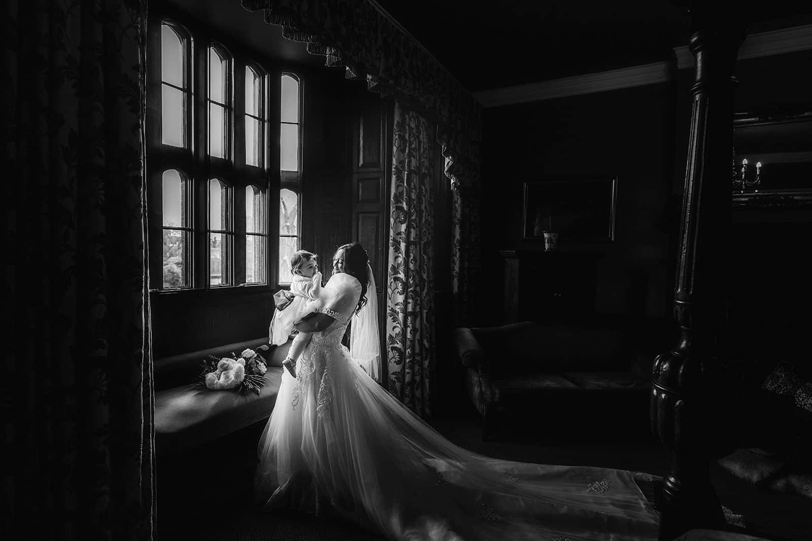 A bride and groom standing in front of a window at Rowton Castle.