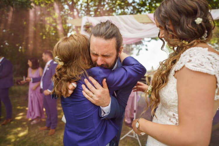 A groom hugging during their Shropshire wedding ceremony, captured by a talented wedding photographer in the region.