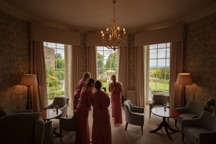 Shropshire wedding photographer captures bridesmaids in front of a window.