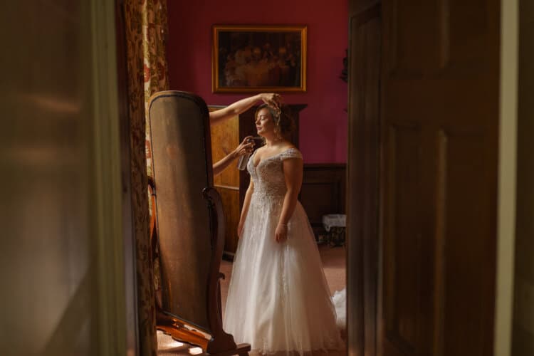 A Shropshire bride is getting ready in a room with a mirror.
