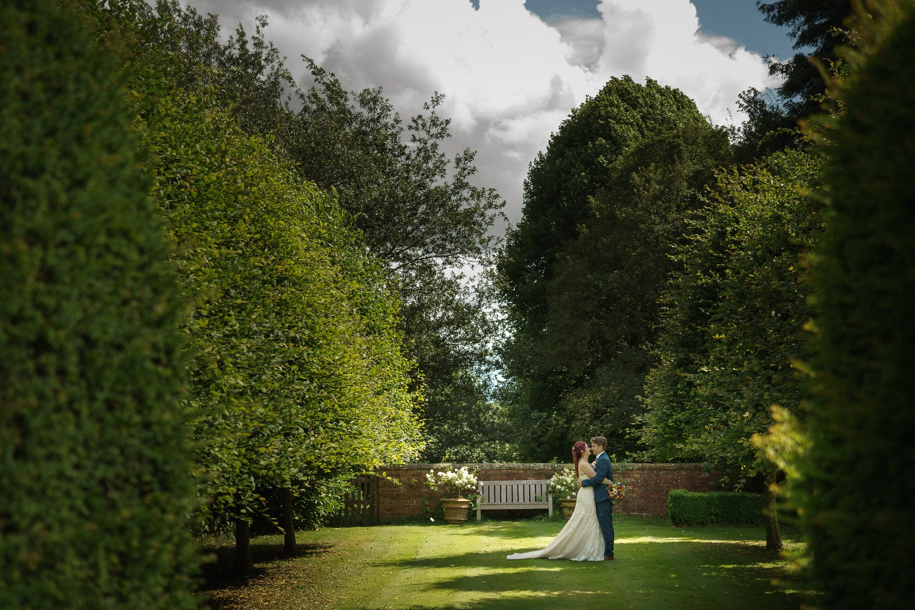 A breathtaking sight of a bride and groom exchanging vows amidst the enchanting garden at Pimhill Barn, Shropshire wedding venue.