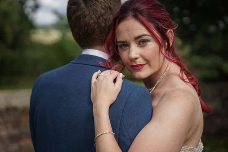 A bride and groom hugging each other in the enchanting Pimhill Barn, capturing their intimate bond on their special day in Shropshire.