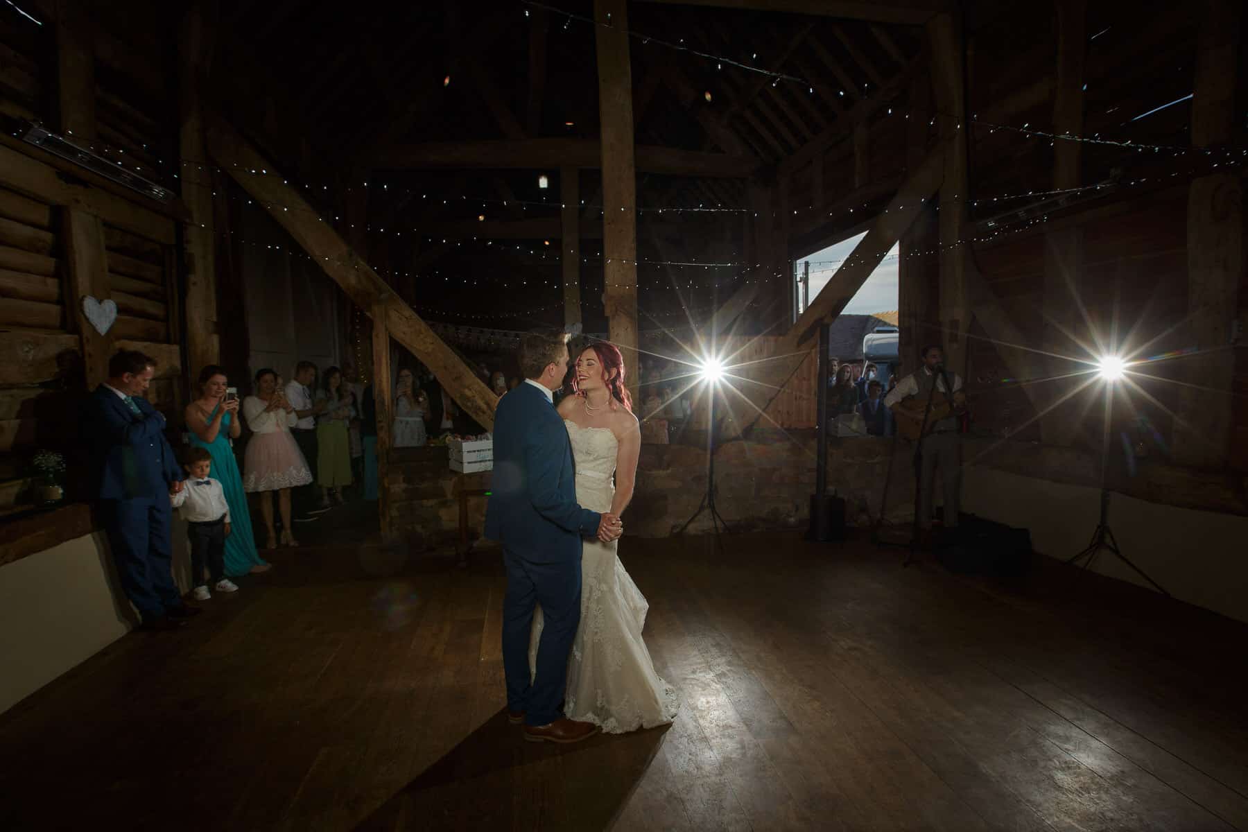 A bride and groom elegantly sway to the music in the rustic ambiance of Pimhill Barn, creating a picture-perfect Shropshire wedding.