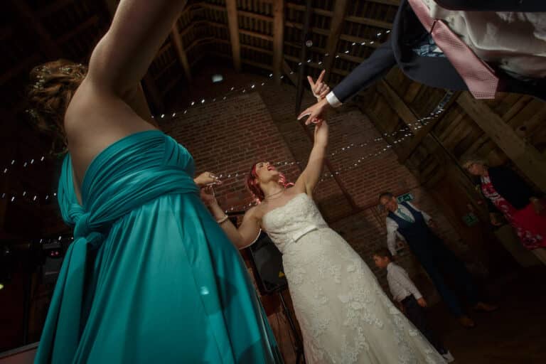 A couple celebrating their Shropshire wedding by gracefully dancing in the rustic elegance of Pimhill Barn.