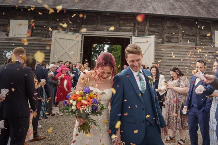 A bride and groom exchange vows at their Shropshire wedding, surrounded by confetti.