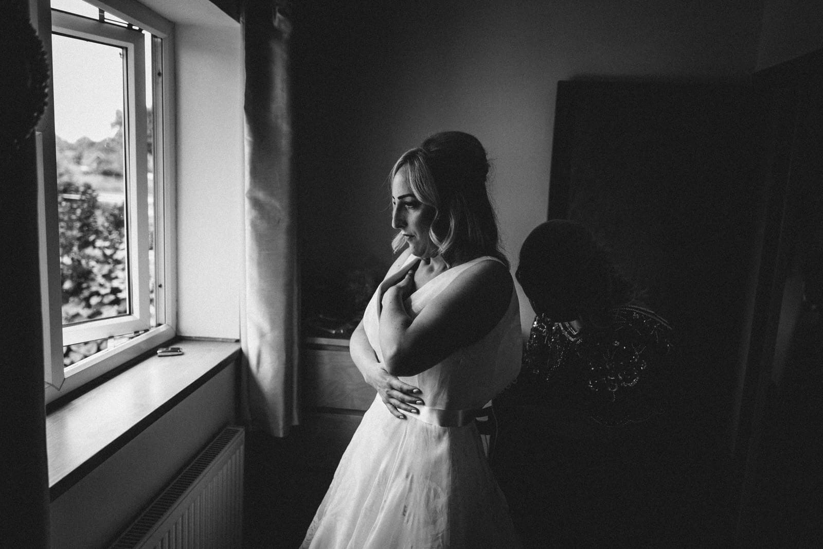 a bride getting ready in front of a window.
